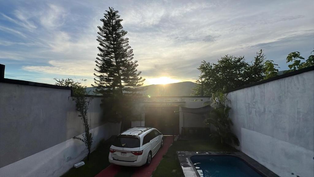 a white car parked in a garage next to a tree at Casa con alberca en Morelos in Barranca Honda