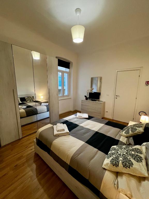 a large bedroom with two beds and a mirror at Appartamento Revoltella16 in Trieste