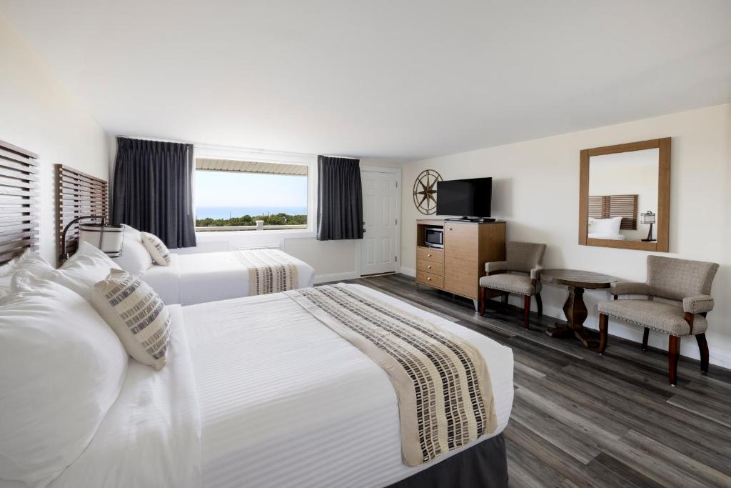 a hotel room with two beds and a table at Dune Crest Hotel in North Truro