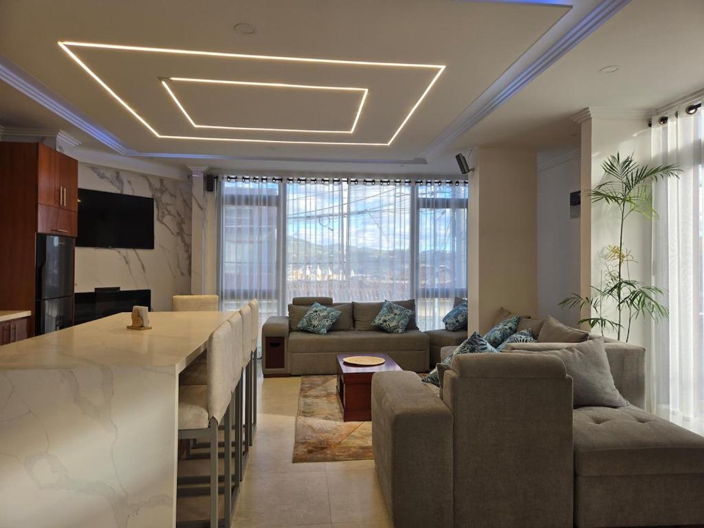 uma cozinha e sala de estar com um sofá e uma mesa em Horizonte Mágico full suite em Cuenca