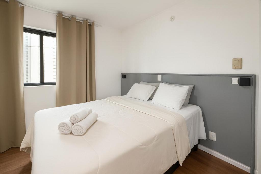 a white bed with two towels on top of it at Hotel Av Ibirapuera 2534 Moema São Paulo 1102 in Sao Paulo