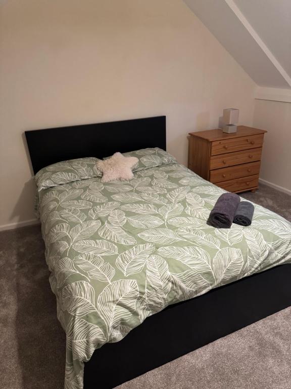 een slaapkamer met een bed en een houten dressoir bij Quarto privativo em uma casa com outros quartos e banheiro compartilhado in Peterborough