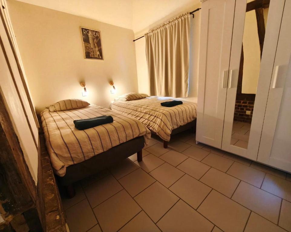 a hotel room with two beds and a window at Le Vue sur Seine in Bardouville