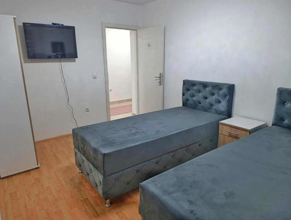 a bedroom with two beds and a tv on the wall at Mujagin Han in Srebrenica