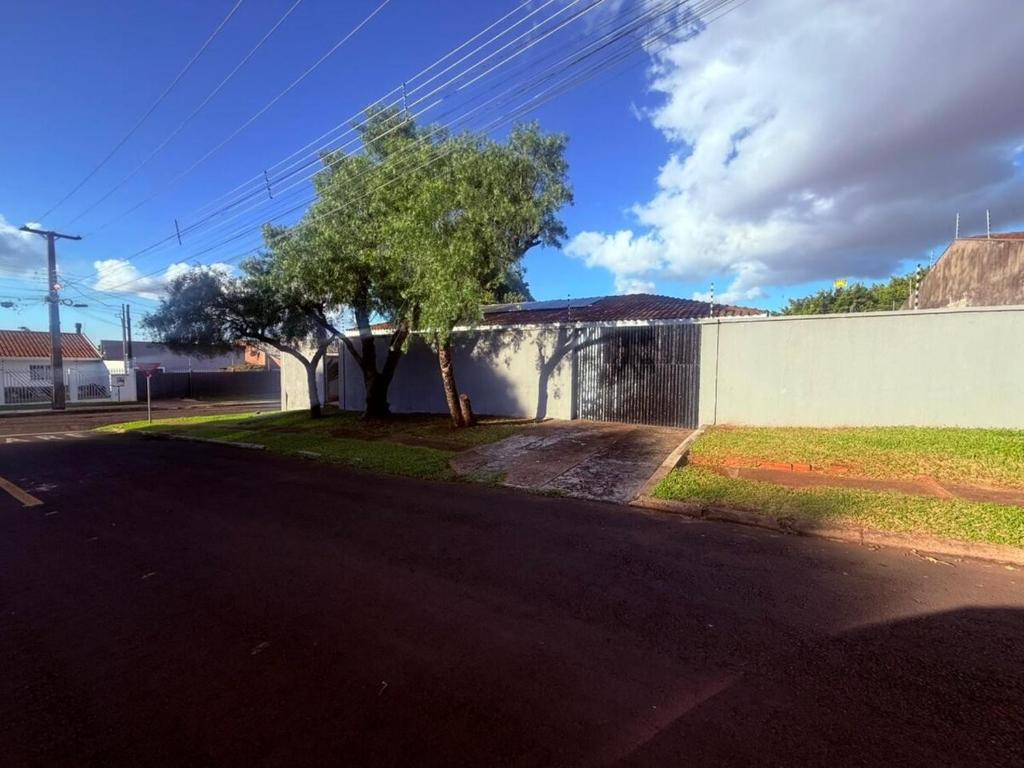 a street with a tree next to a wall at Casa Aconchegante in Foz do Iguaçu
