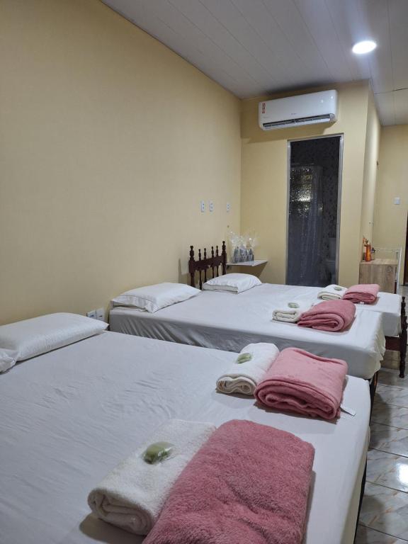 - une rangée de lits dans une chambre avec des serviettes dans l'établissement Quarto completo com varanda, à Belém