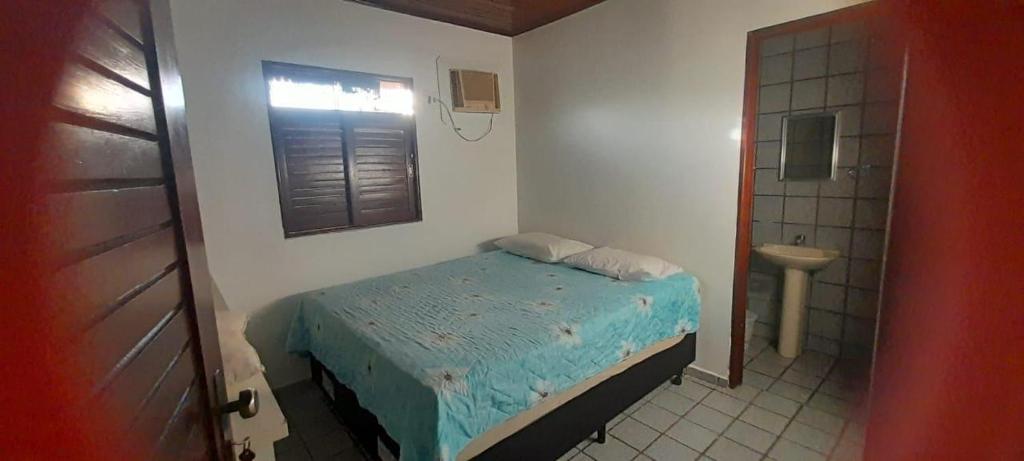 ein kleines Schlafzimmer mit einem kleinen Bett und ein Badezimmer in der Unterkunft Casa de Praia em Paripueira in Paripueira