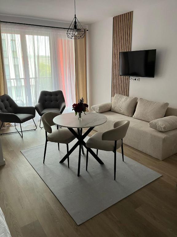 フロレシュティにあるApartament Abatorului Cluj-Florestiのソファとテーブルと椅子のあるリビングルーム