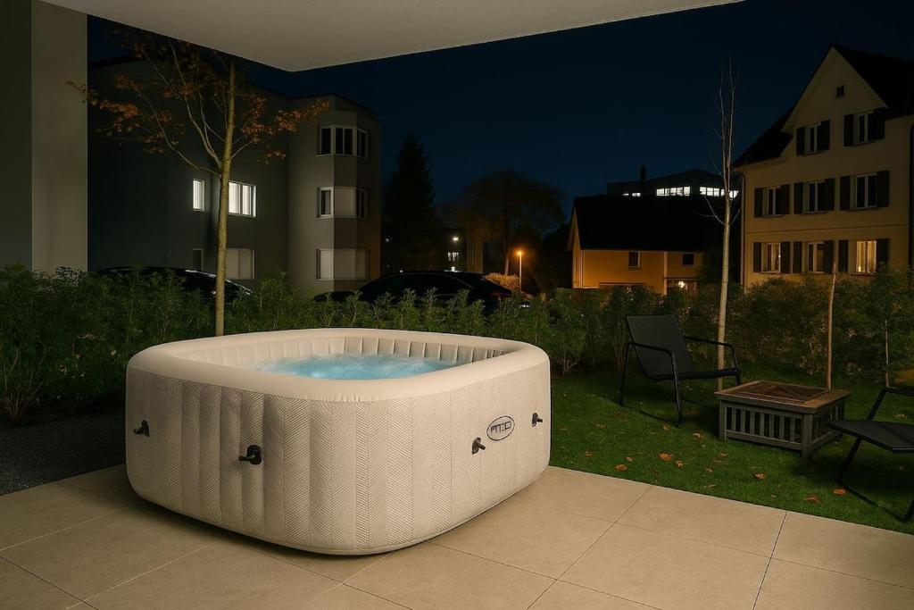 a hot tub sitting on a patio at night at Lux Line Apartment in Zürich