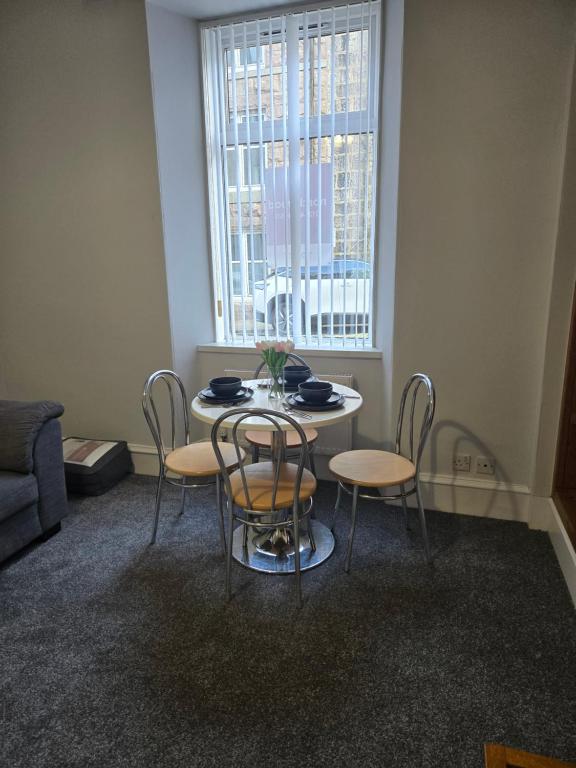 a table and chairs in a room with a window at Heart of Aberdeen in Aberdeen