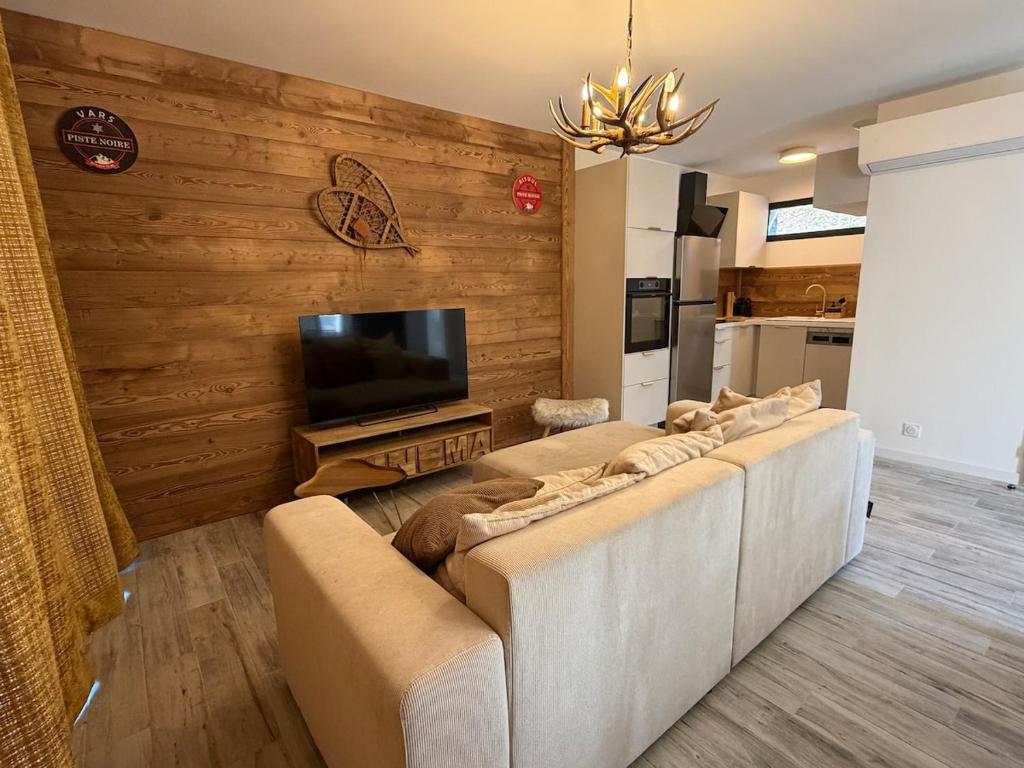 a living room with a couch and a flat screen tv at chalet Des Cimes de Risoul in Risoul