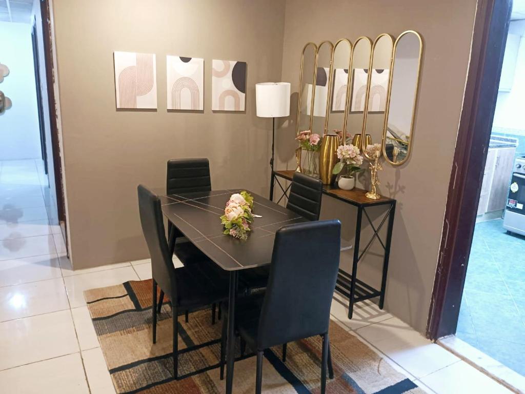 a dining room with a table and chairs and mirrors at Beautiful 3-bedroom Apartment in Sharjah