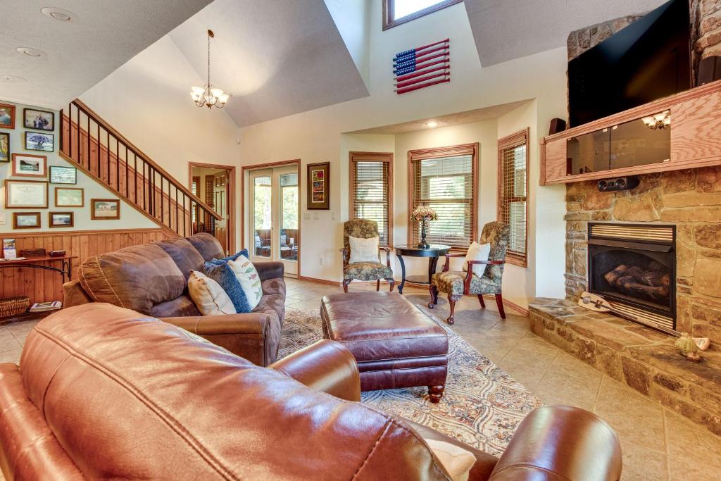 Una sala de estar con muebles de cuero y chimenea. en TroutFest Riverfront Norfork Home, Great Fishing, en Norfork