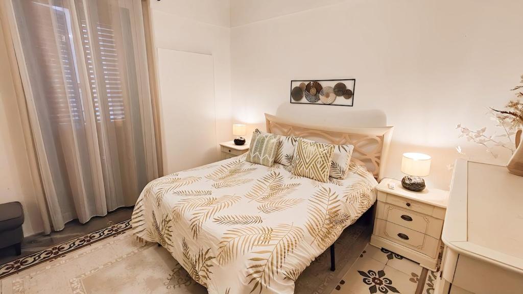 a bedroom with a bed and a dresser with two lamps at Private Home with Sunset and Gallipoli Views in Parabita