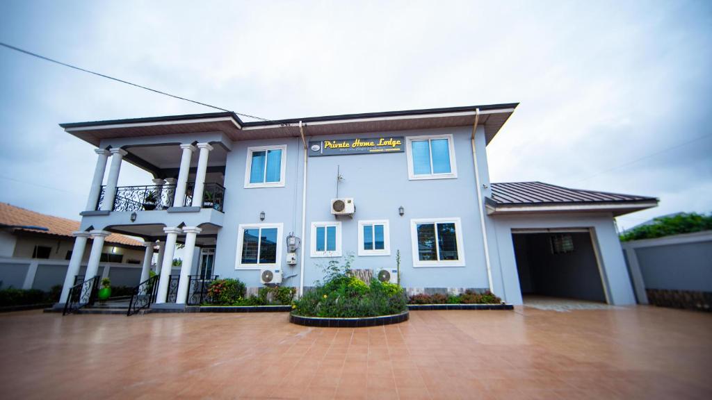 ein großes weißes Haus mit einer Auffahrt in der Unterkunft Private Home Lodge in Accra
