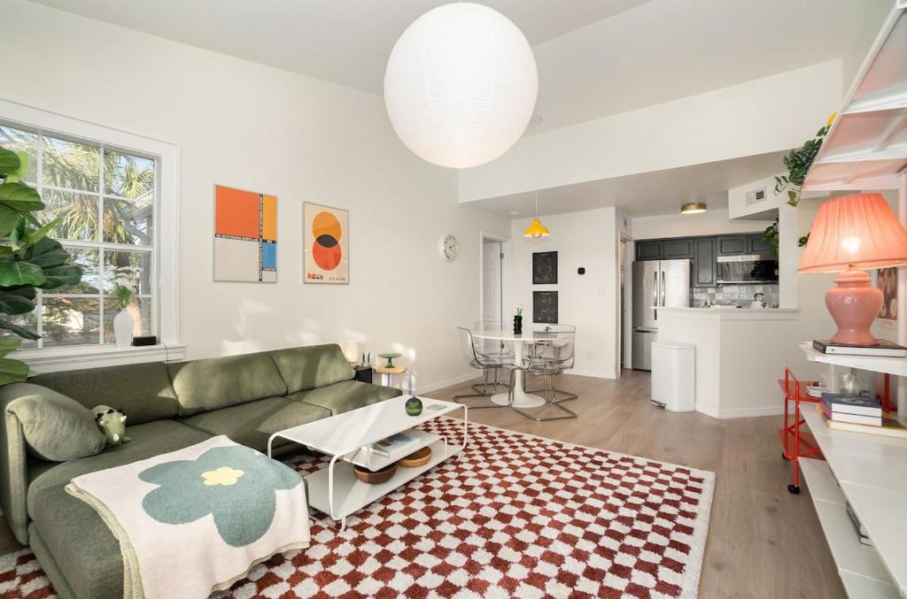a living room with a green couch and a kitchen at Modern Bauhaus Condo with Pool in Indialantic