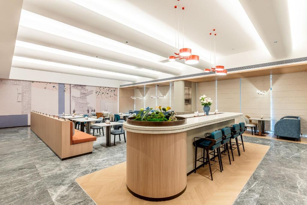 a conference room with a bar and tables and chairs at Holiday Inn Express Jincheng New District by IHG in Jincheng
