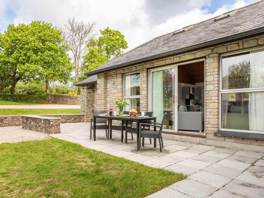 a patio with a table and chairs in front of a house at 3 Bed in St. Mellion 87719 in St Mellion