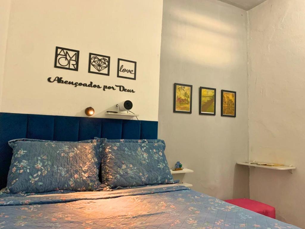 a bedroom with a bed with a blue head board at Quarto privativo La Paz in Aracaju