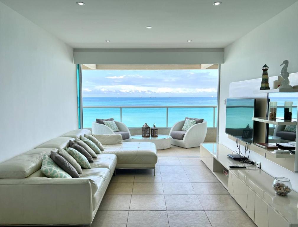 CarolinaBeach front Ocean view, pool Family Apt Salinas的客厅设有大沙发,享有海景