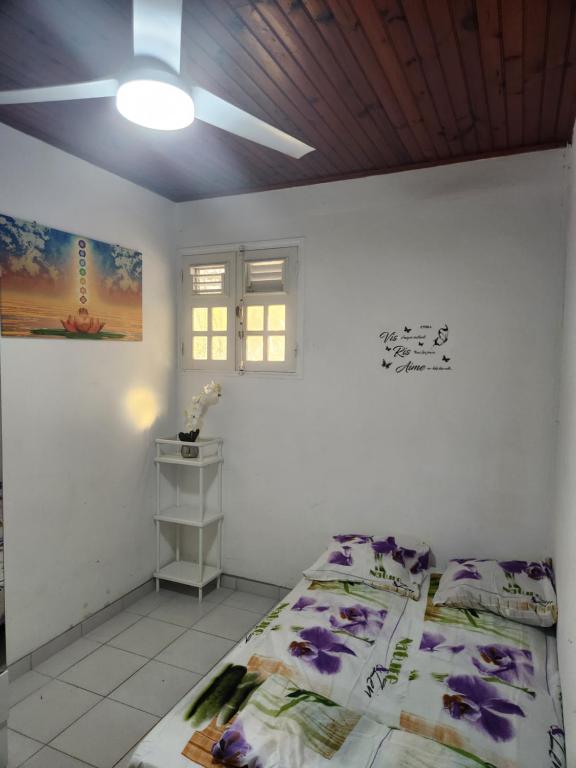 een witte kamer met een bed en een plafond bij Chambre lumineuse chez L'habitant in Le Lamentin