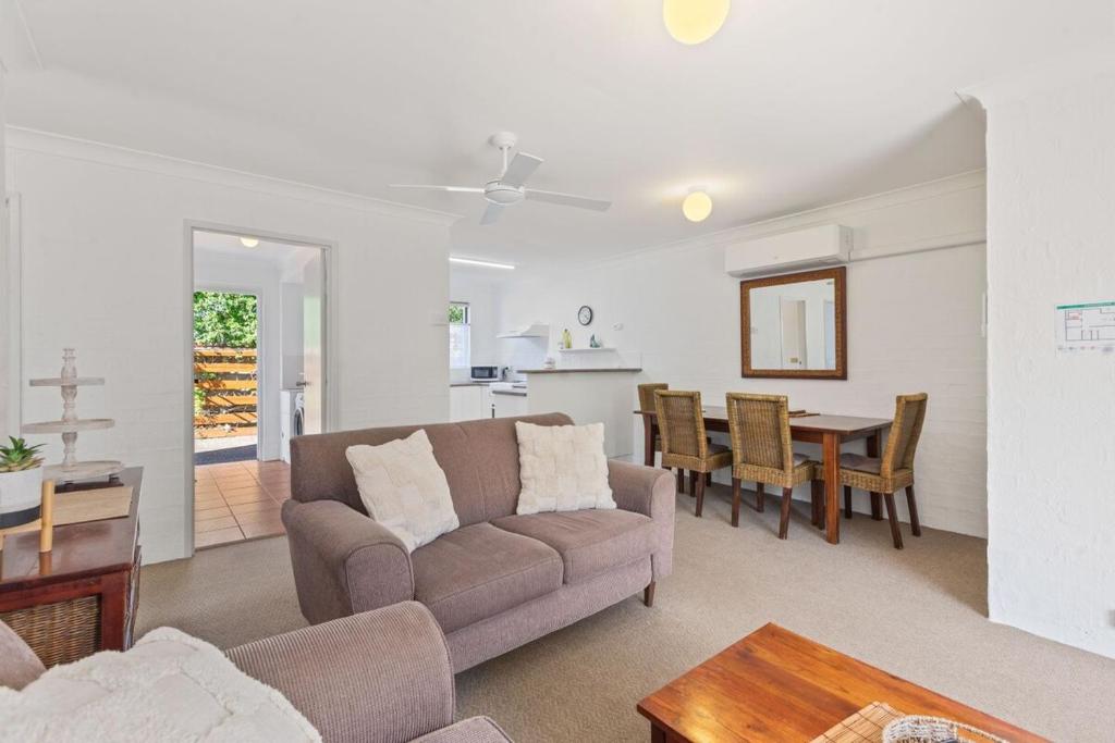 a living room with a couch and a table at The Sand Nook - 2 Bedroom Fishpen Apartment in Merimbula