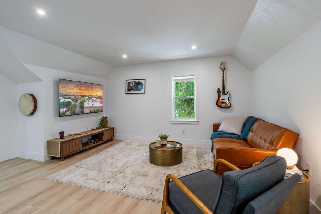 ein Wohnzimmer mit einem Sofa und einer Gitarre in der Unterkunft The Key Reno'd Historic 1BD 1 Mile to UF & DT in Gainesville