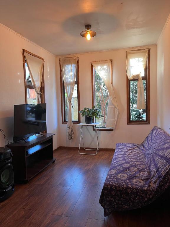 a living room with a couch and a flat screen tv at Cabaña 2 habitaciones matrimoniales in Valdivia