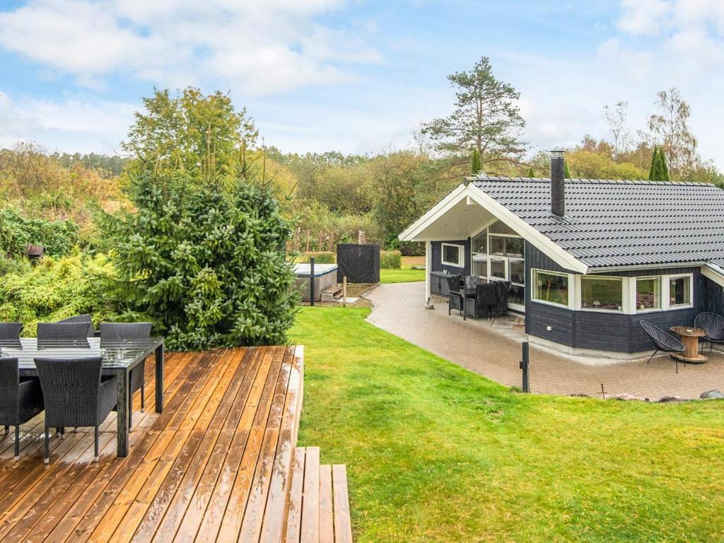 ein Haus mit einer Terrasse mit einem Tisch und Stühlen in der Unterkunft 8 person holiday home in Ebeltoft-By Traum in Ebeltoft