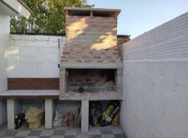 a building with a fireplace in the side of it at Casa con pileta,quincho ymas servicios para vos in Santa Teresita