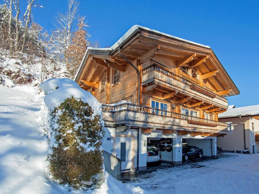 une cabane en rondins dans la neige avec une cour dans l'établissement Idylle am Waldrand, à Brixen im Thale