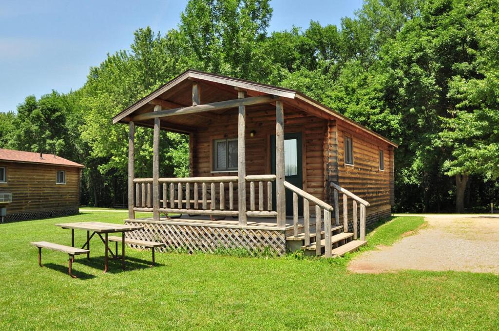 Cabaña de madera con mesa de picnic en el césped en Fremont RV Campground Cottage 28, en Fremont