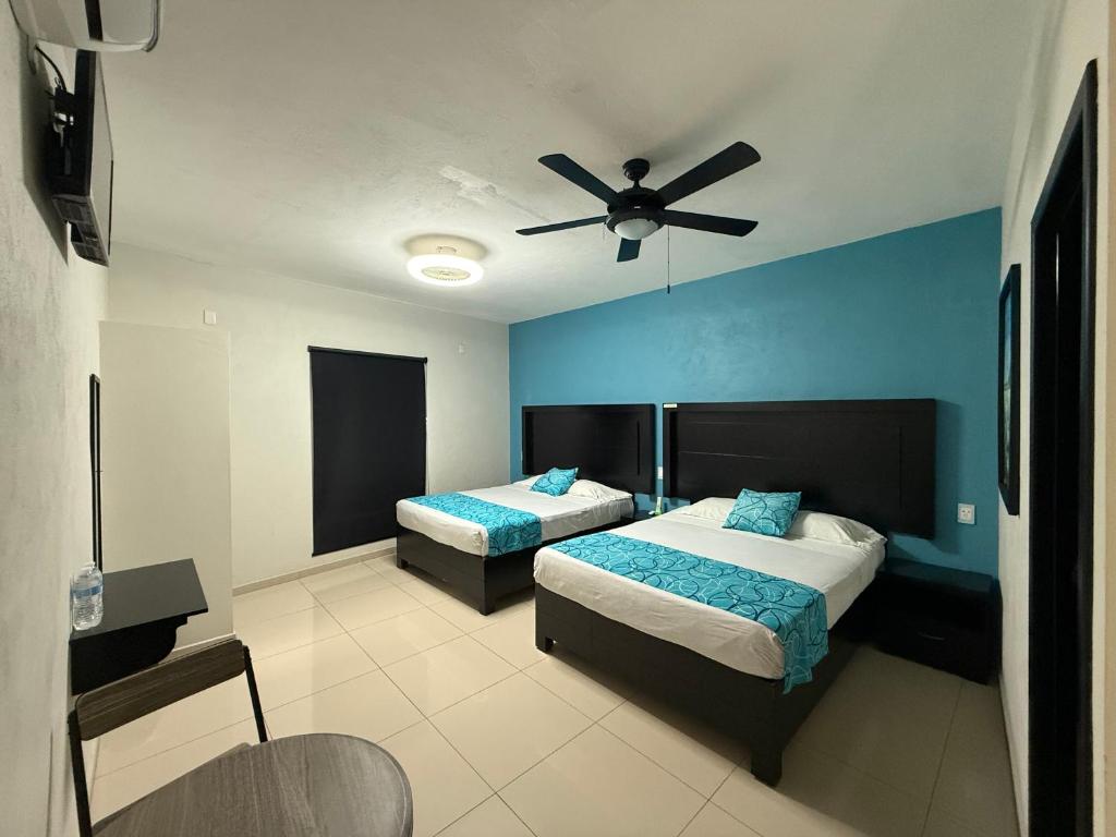 ein Schlafzimmer mit zwei Betten und einem Deckenventilator in der Unterkunft Hotel Santa Teresa in Tequila