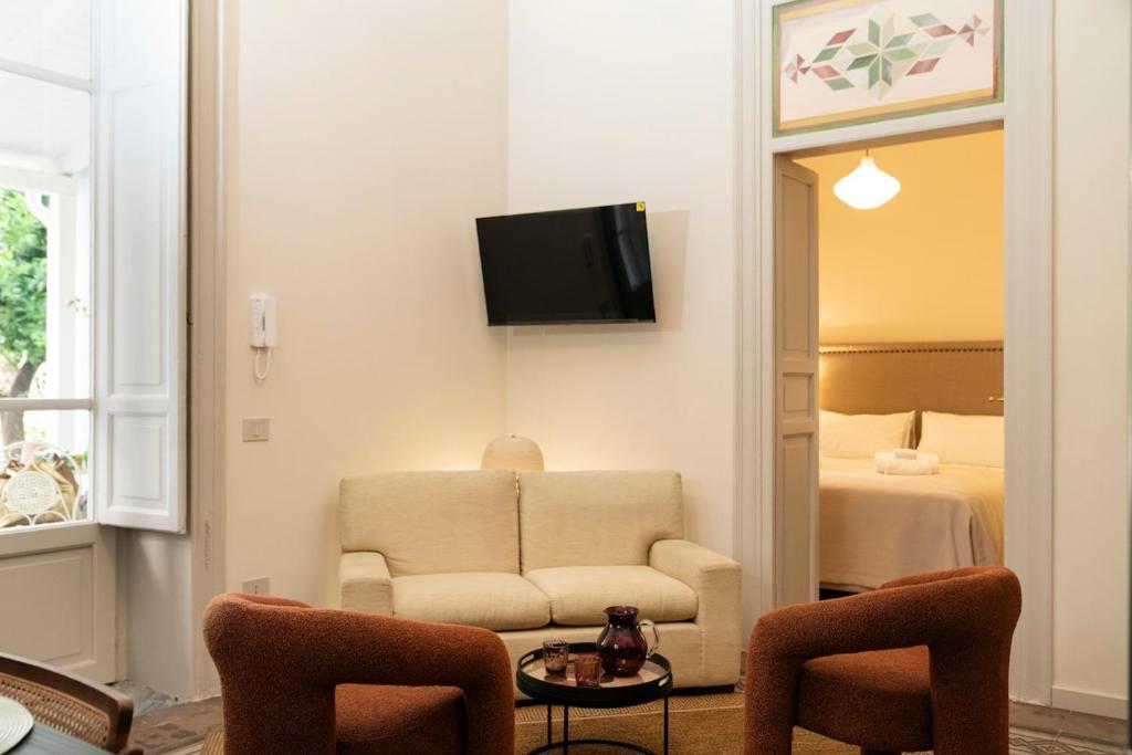 a living room with a couch and a bedroom at Silvia Home Suite in Palermo