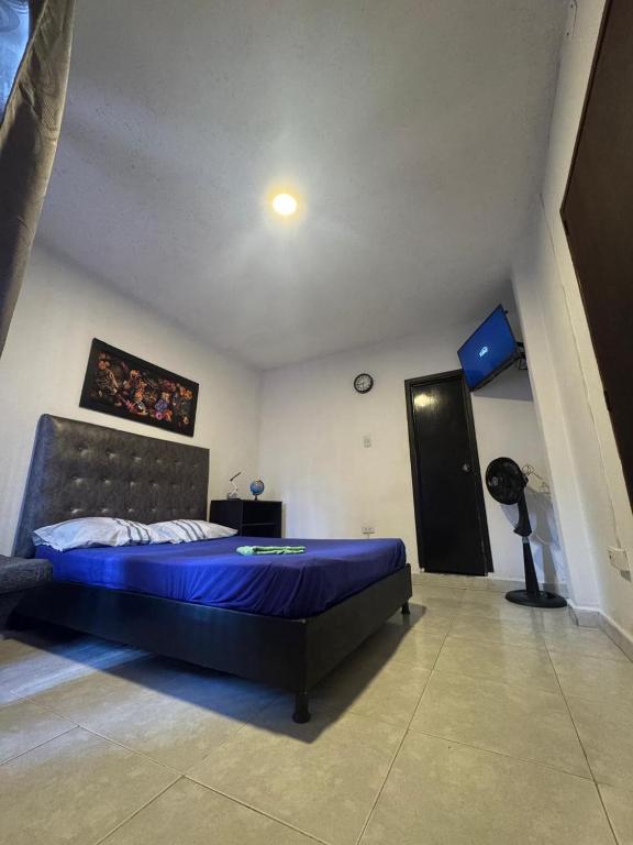 ein Schlafzimmer mit einem blauen Bett in einem Zimmer in der Unterkunft Casa Osiris in Cali