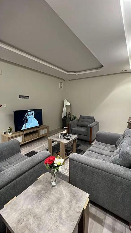 a living room with couches and a flat screen tv at Apartment, room, elegant and comfortable hall, and smart entrance in Al Madinah