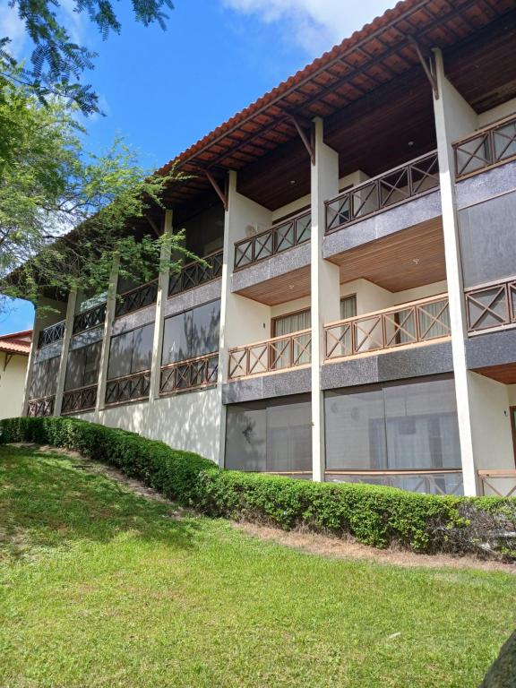 an apartment building with balconies and a lawn at Flat Monte Castelo - Gravatá - Até 5 pessoas, próximo da área de lazer in Sairé