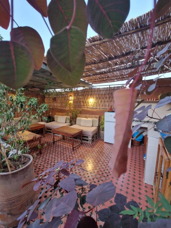 eine Terrasse mit Tisch, Stühlen und Pflanzen in der Unterkunft Medina Oasis Hostel in Marrakesch