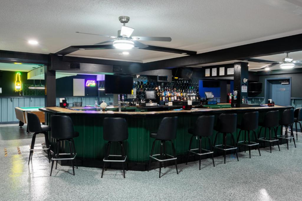 a bar with black stools in a room at Budget Inn & Suites Baton Rouge in Baton Rouge