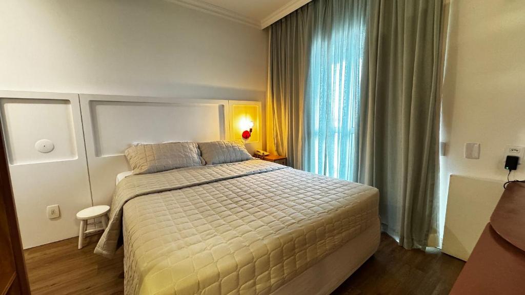 a bedroom with a large bed and a window at HOTEL PERDIZES - FLAT Executivo - 1402 in Sao Paulo