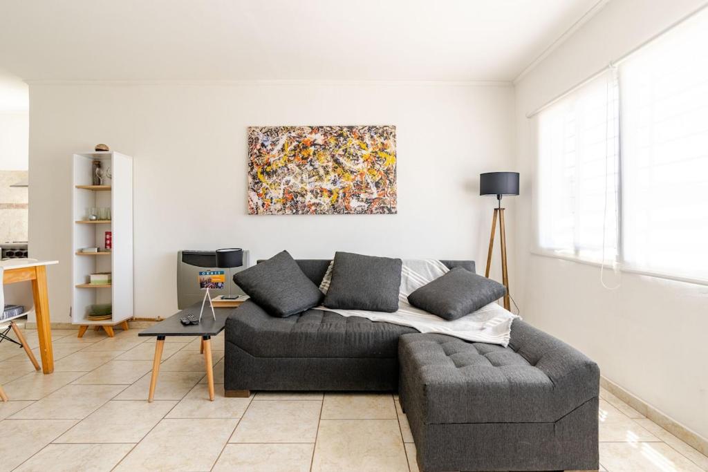 Una sala de estar con un sofá y un cuadro en la pared. en Tu Casa en San Rafael Centro y Confort, en San Rafael