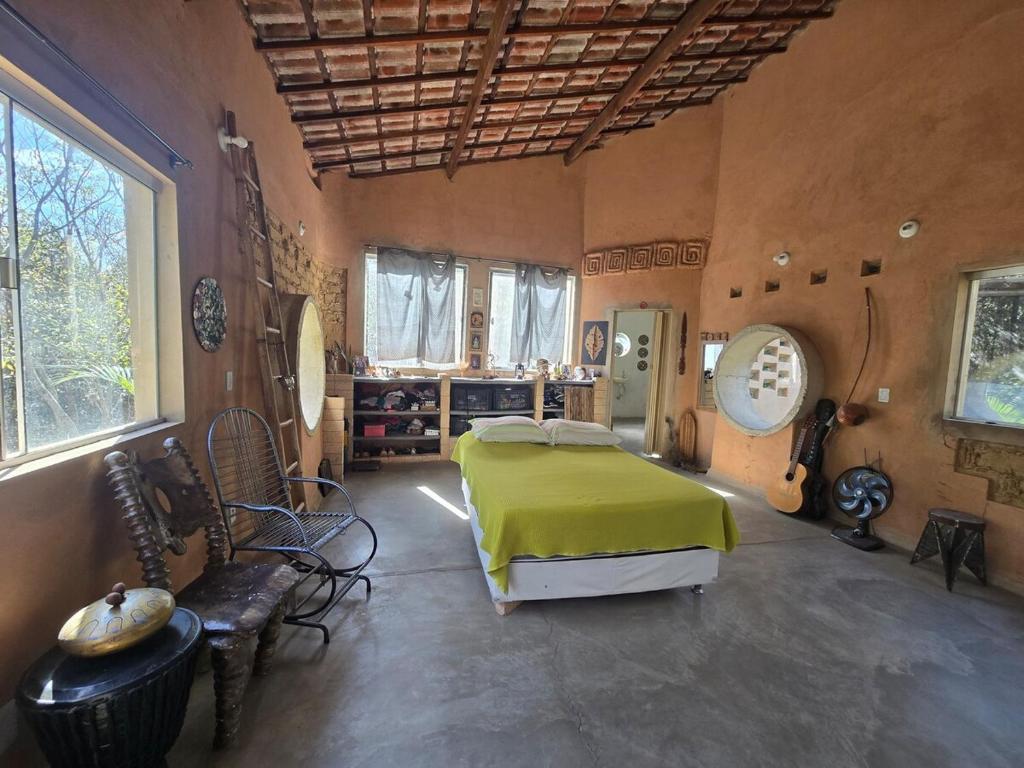 ein Schlafzimmer mit einem Bett, auf dem eine grüne Decke liegt in der Unterkunft Casa Ecológica in Rio de Contas