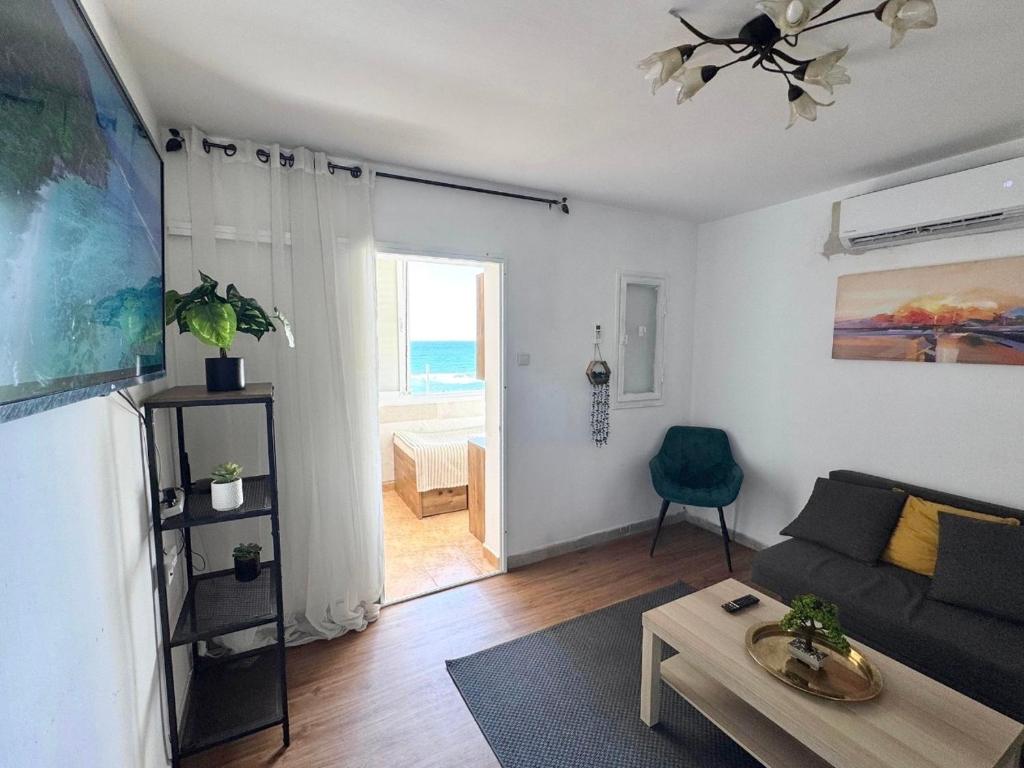 a living room with a couch and a table at Seaside Vacation in Haifa