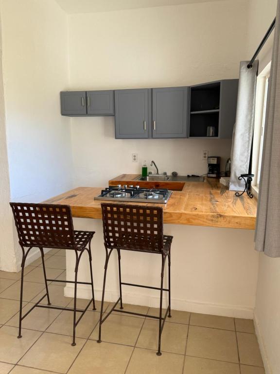 a kitchen with two chairs and a wooden counter top at Las Casitas en Todos Santos in Todos Santos