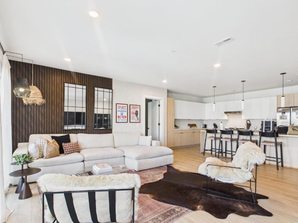 Una sala de estar con un sofá blanco y una cocina. en Hyve - Mahogany - Walk to Broadway, en Nashville