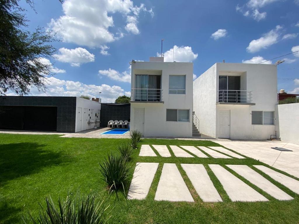 Una gran casa blanca con un patio de césped. en Casa Mezquite, en Tequisquiapan