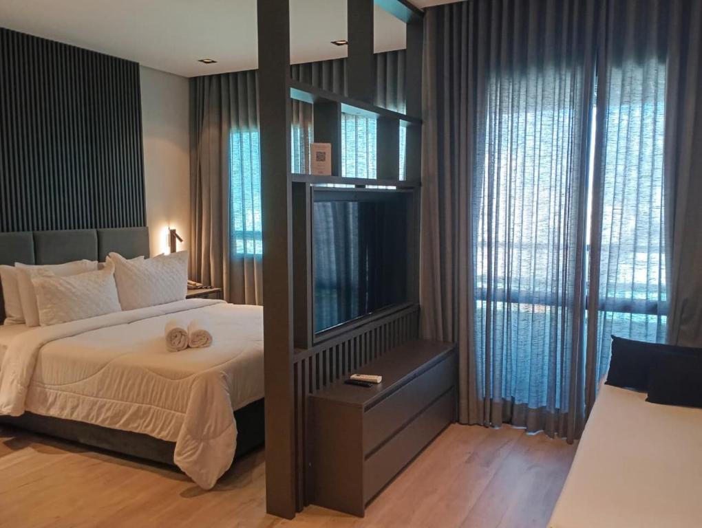Un dormitorio con una cama y una ventana grande. en Hotel B Tree Premium Jardins, en São Paulo