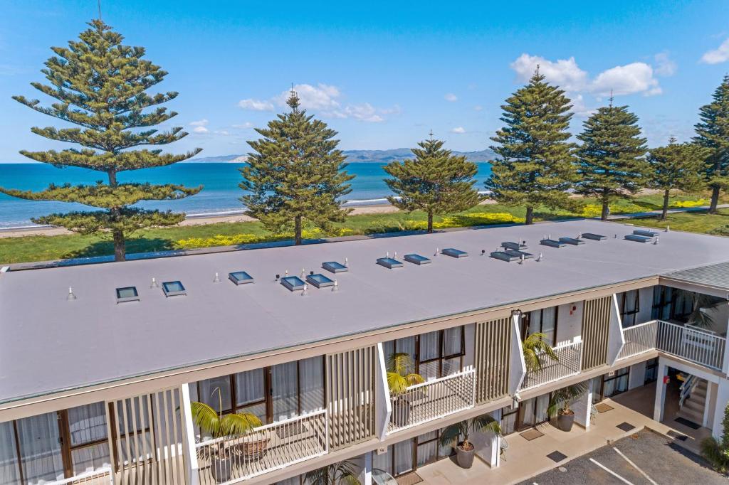 an aerial view of a building with the ocean in the background at Whispering Sands Beachfront Motel in Gisborne