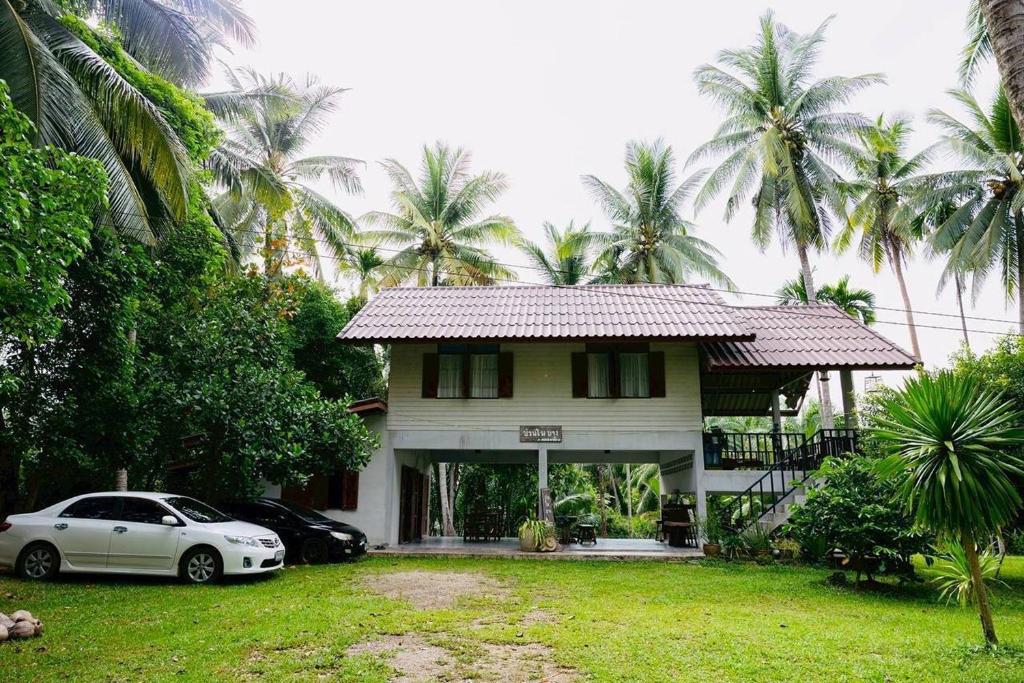 a white car parked in front of a house at Baan Nai Bang in Suratthani