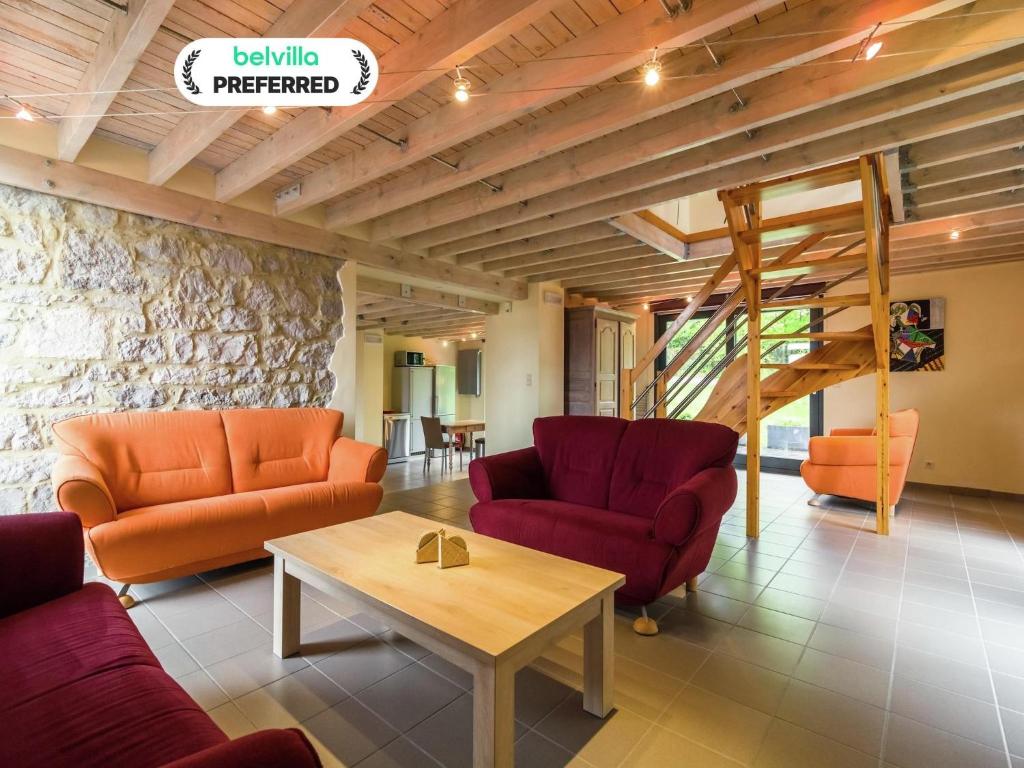 a living room with two couches and a table at Cozy Bedrooms Cottage, Soumoy in Soumoy